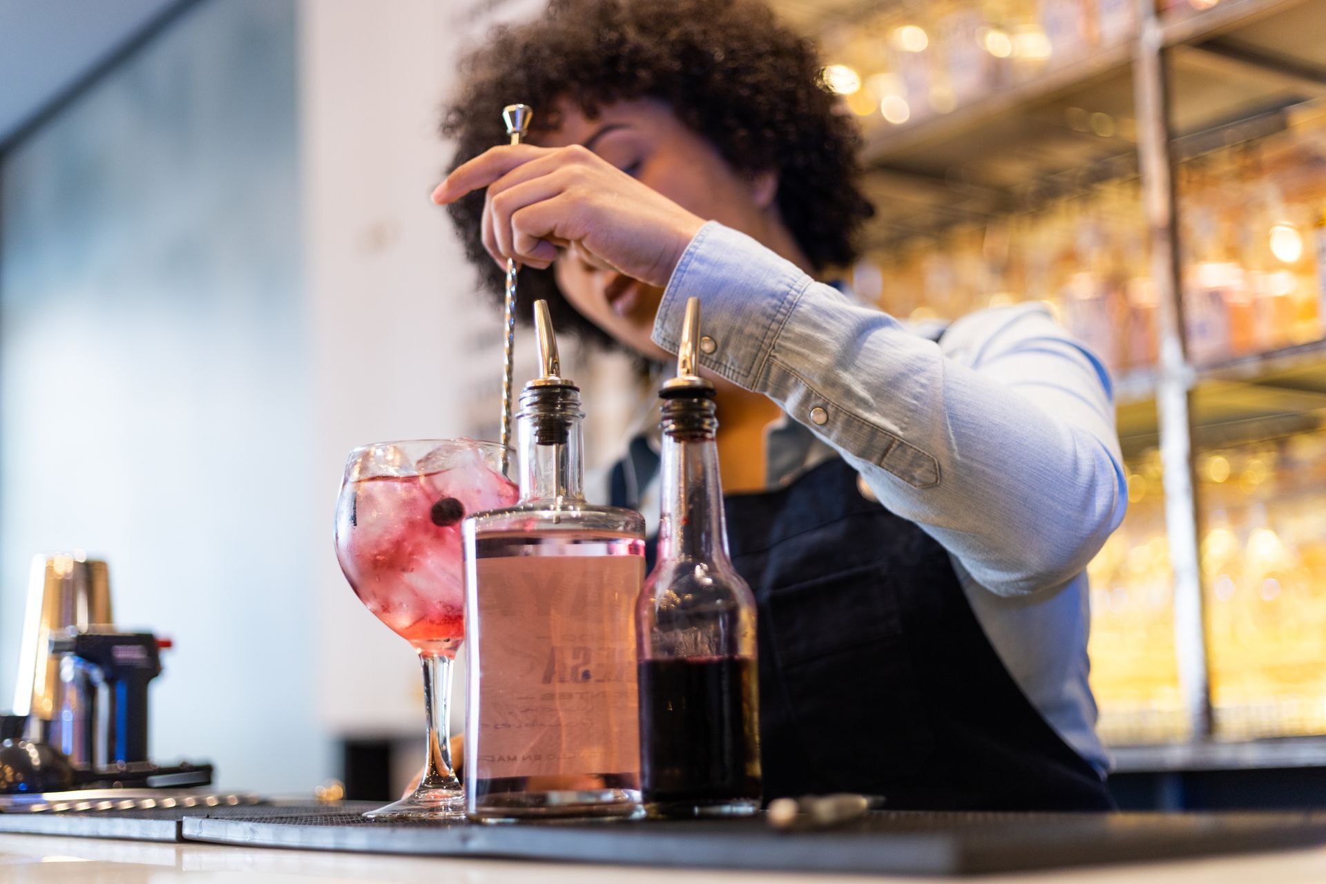 A bartender is preparing a drink at a bar.