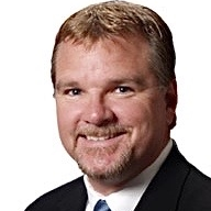 A man in a suit and tie is smiling for the camera.