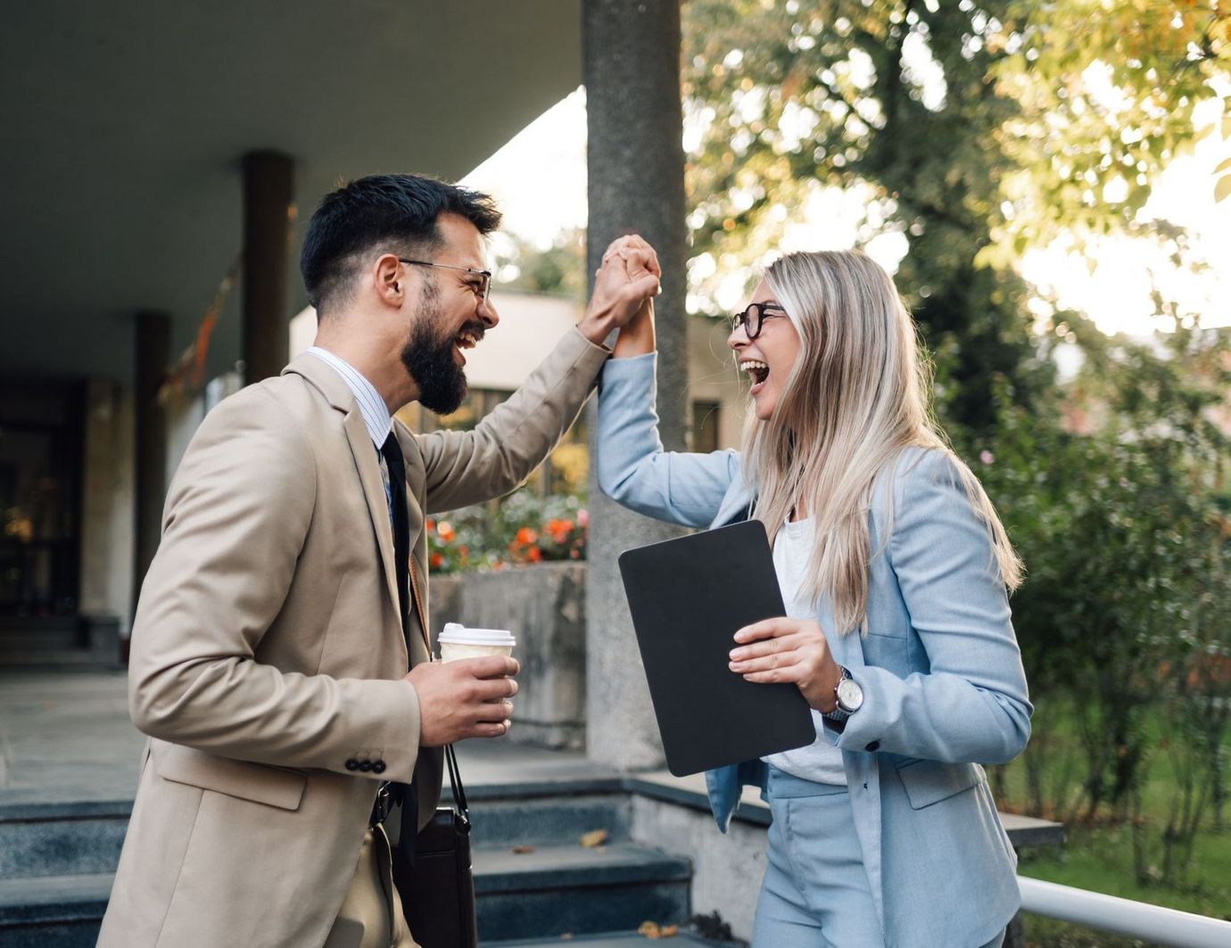 A man and a woman are giving each other a high five.