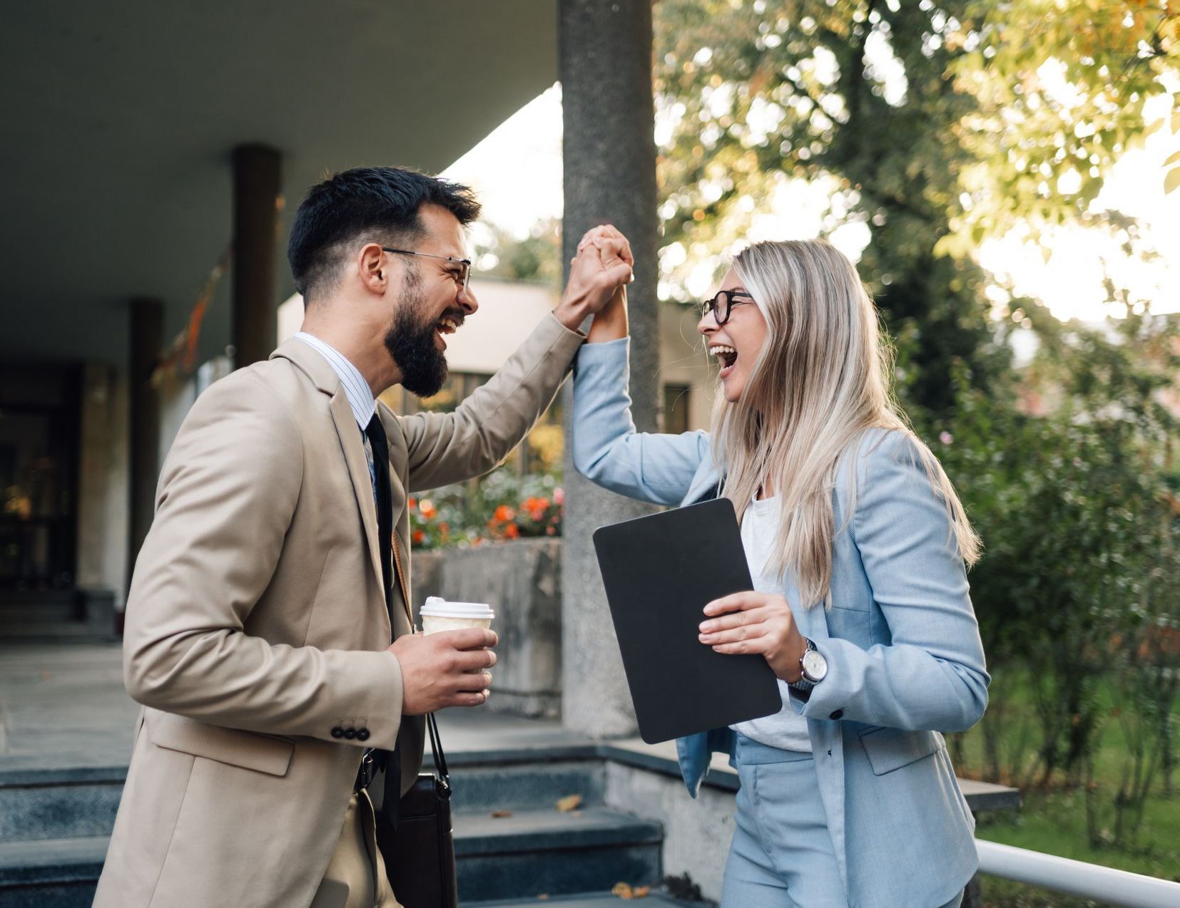 A man and a woman are giving each other a high five.