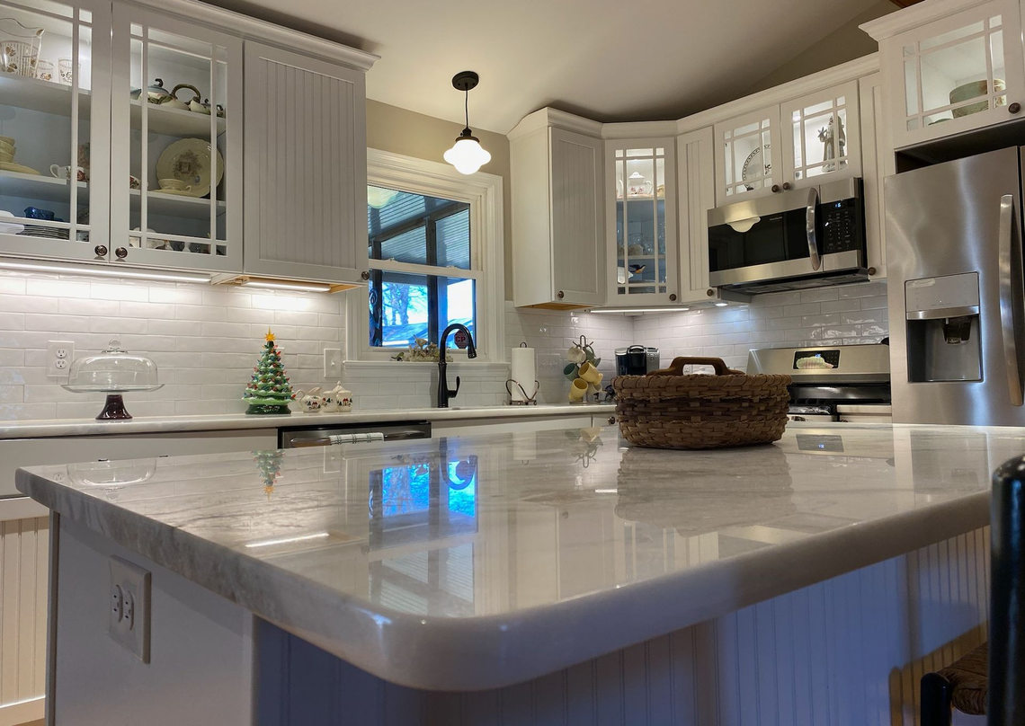 A kitchen with a large island and stainless steel appliances.