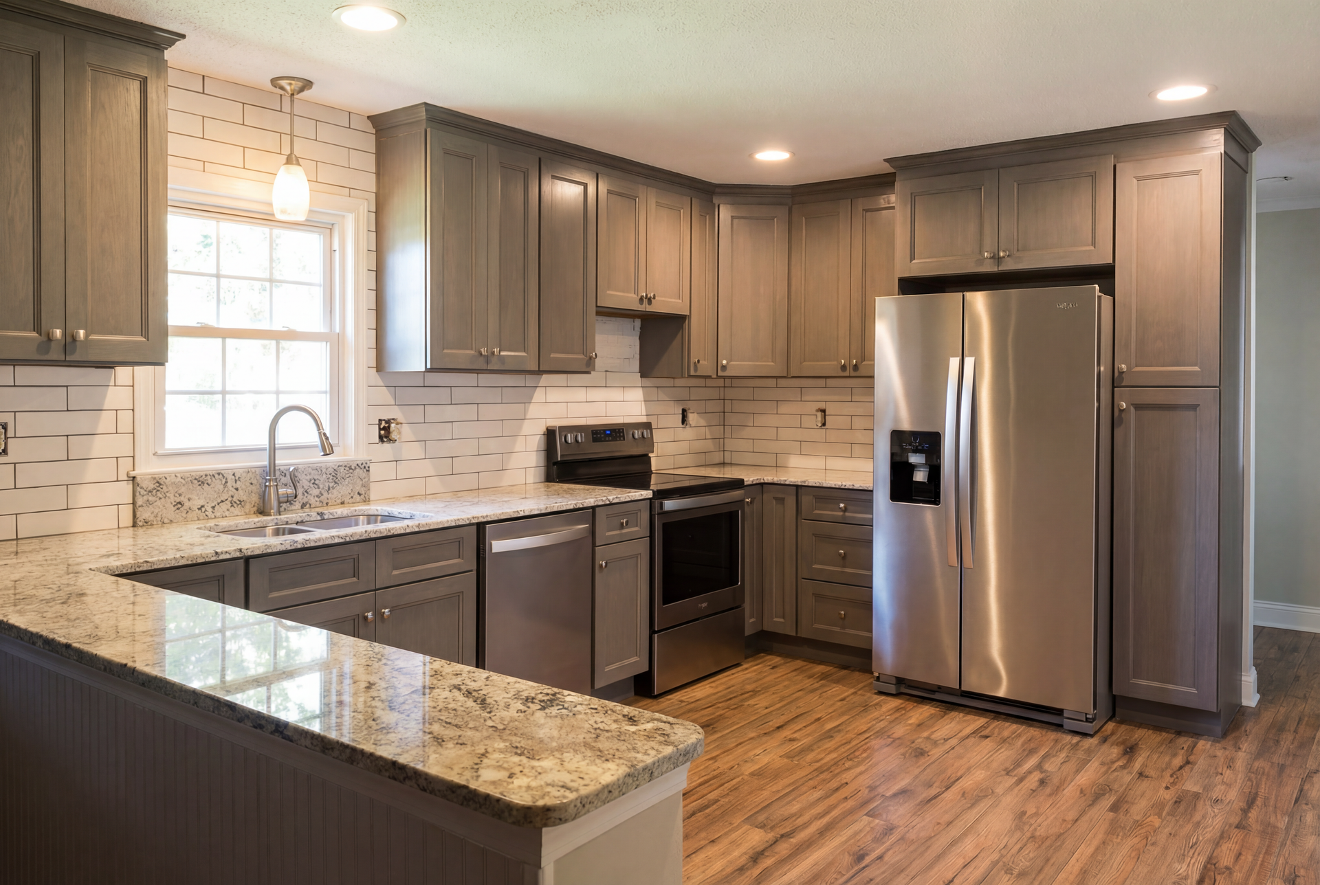 Gray kitchen with granite countertops, stainless steel appliances, and wood floors.