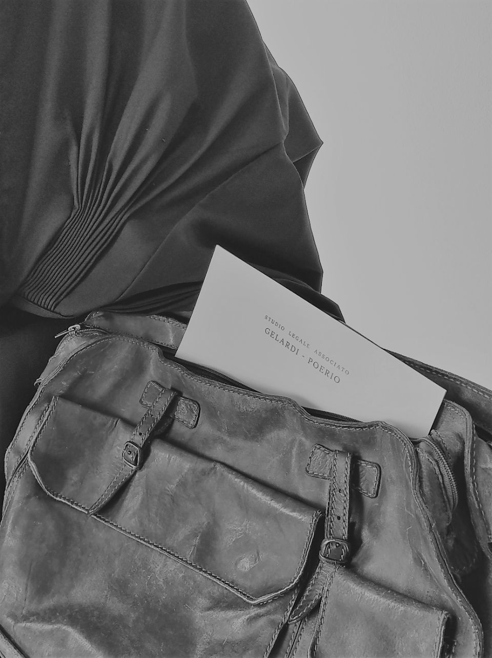 Foto in bianco e nero di una borsa con all'interno dei documenti