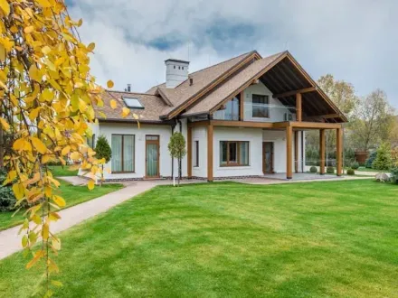 A large house with a large lawn and a concrete sidewalk in front of it, installed by NWCE, the most reliable concrete contractors in Seattle. 
