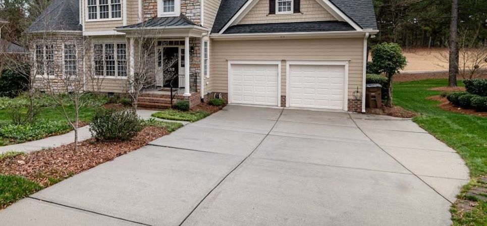 A large house with a concrete driveway in front of it