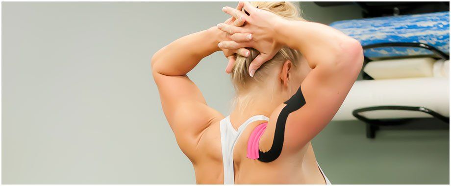 A woman is wearing kinesio tape on her back.