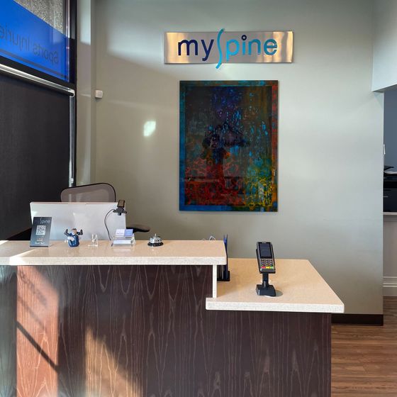 A man is standing at a reception desk talking to a woman.