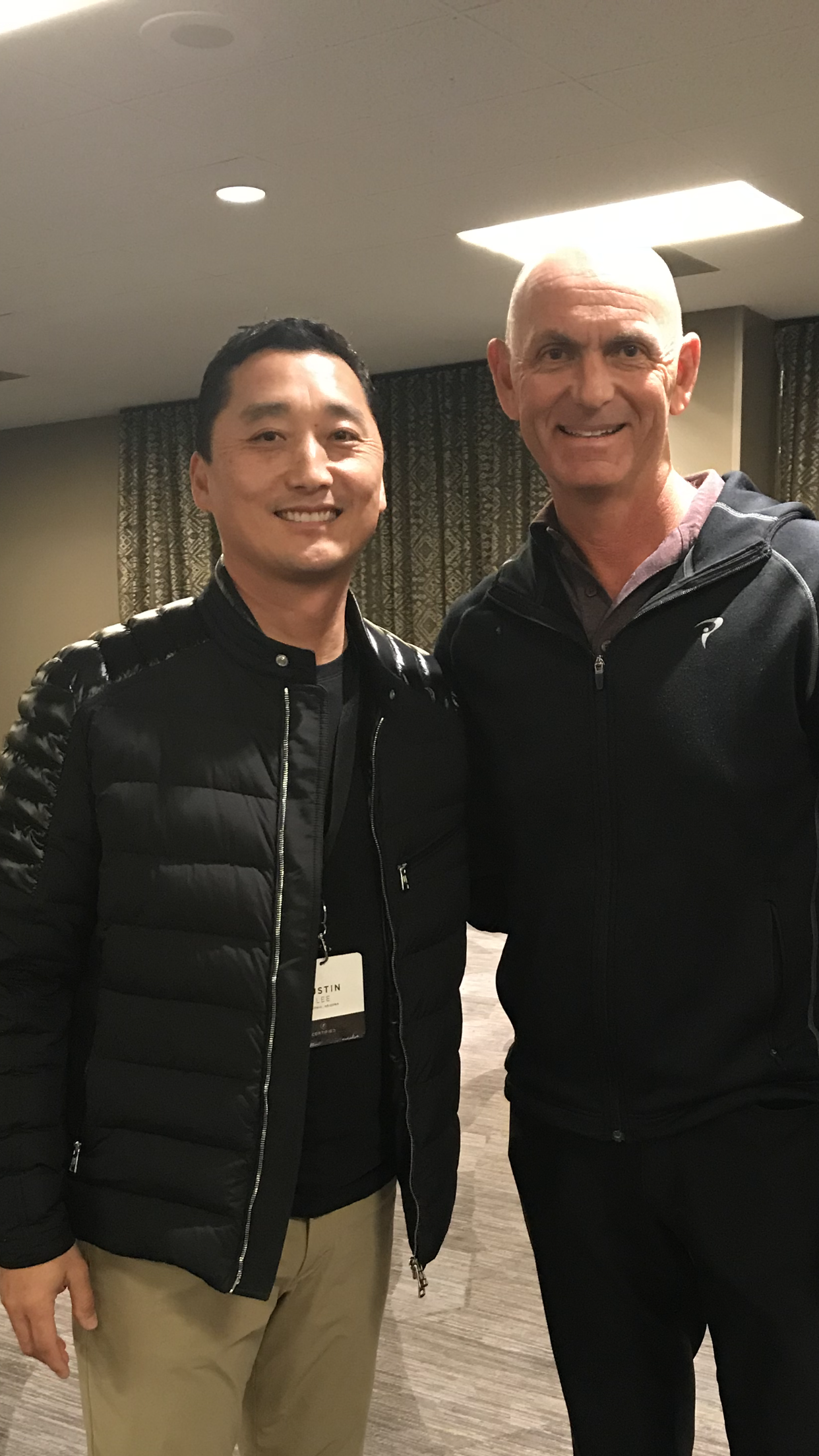 Two men are posing for a picture together in a room.