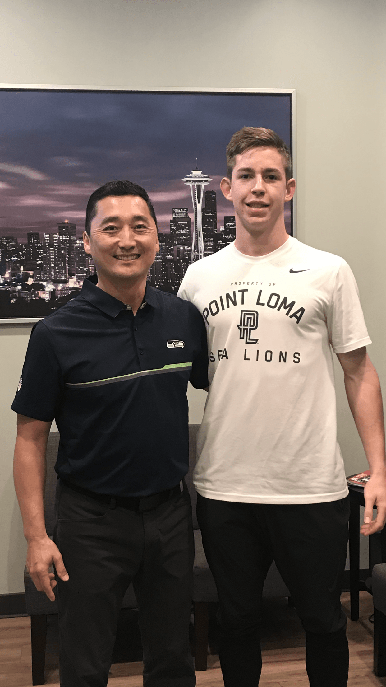 A man and a boy are posing for a picture in a room.