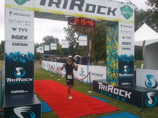 A runner crosses the finish line of a tri rock race
