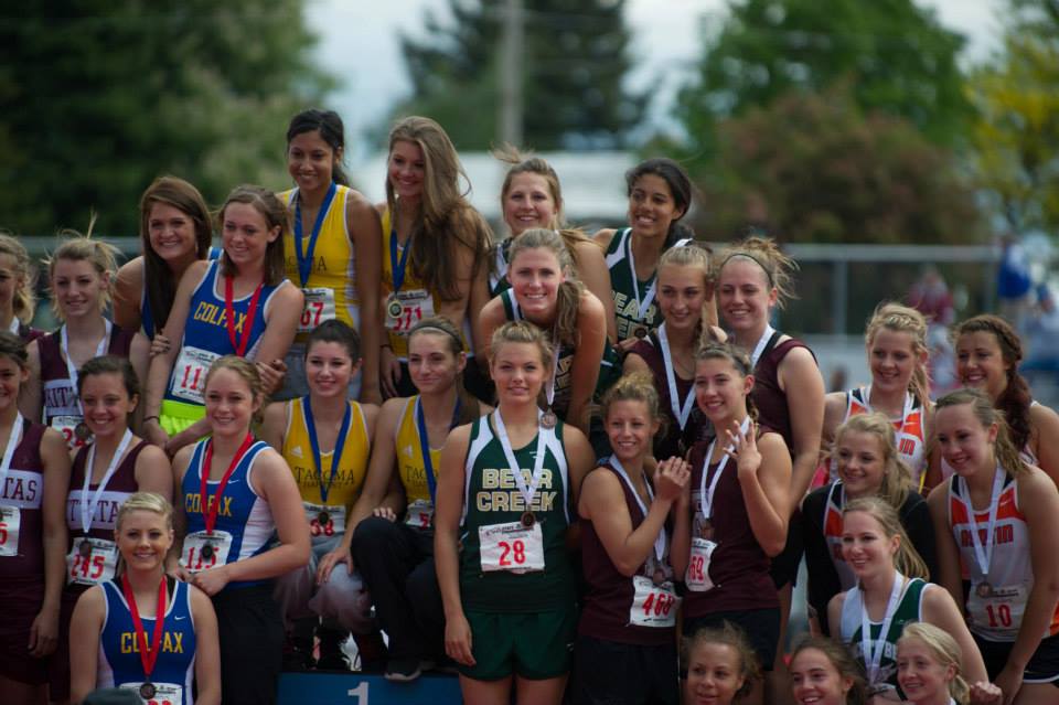 A group of female athletes posing for a picture with one wearing a jersey that says bear valley