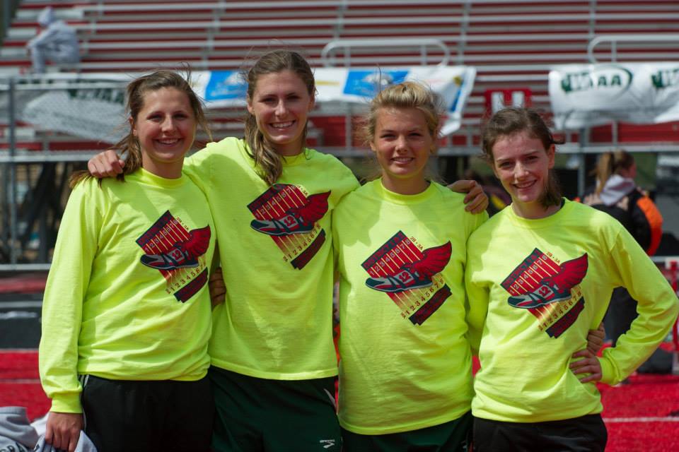 Four women wearing neon yellow shirts are posing for a picture