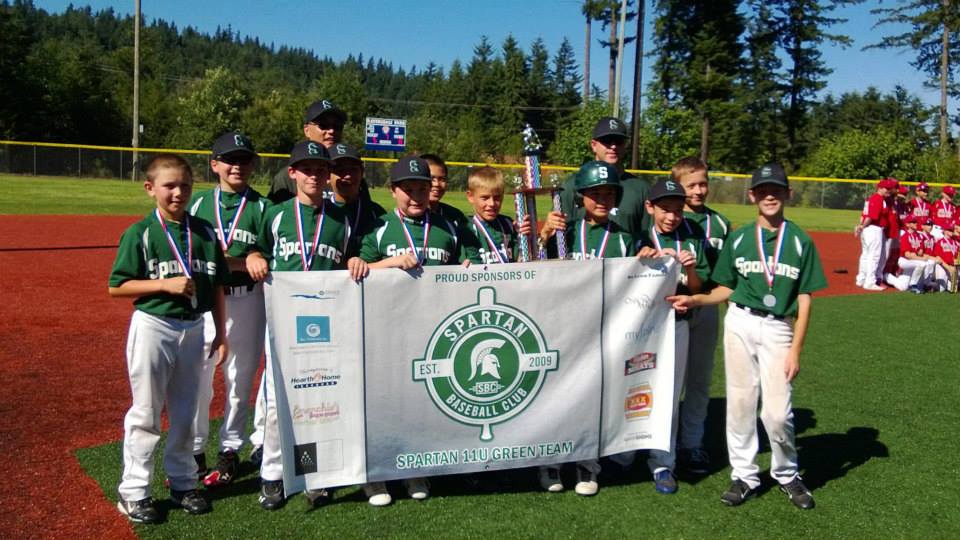 A group of baseball players holding a banner with the letter g on it