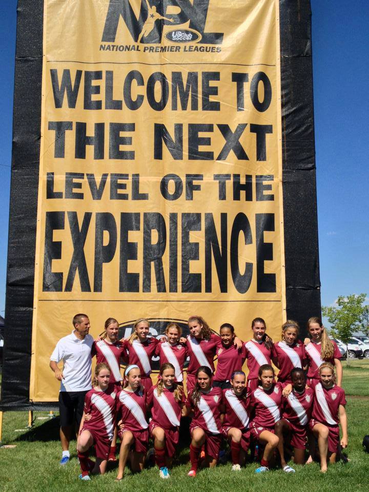 A group of kids are posing in front of a sign that says welcome to the next level of the experience