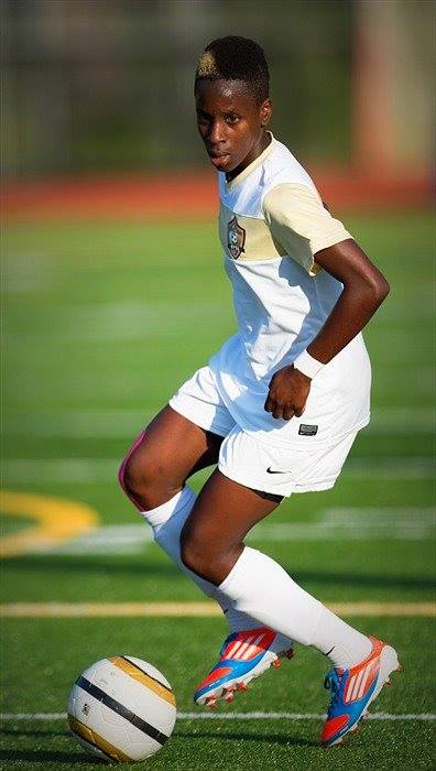 A young boy is playing soccer on a field.