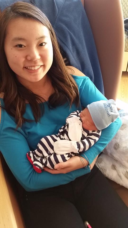 A woman is holding a newborn baby in her arms.