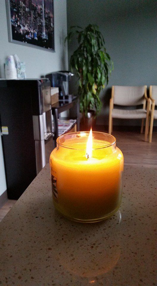 A candle is sitting on a counter in a waiting room.