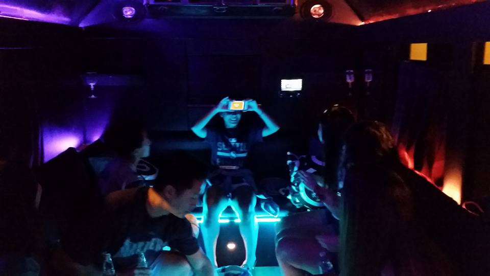 A group of people are sitting in a dark room with glow in the dark lights.