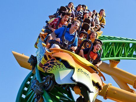 A group of people are riding a roller coaster at an amusement park.