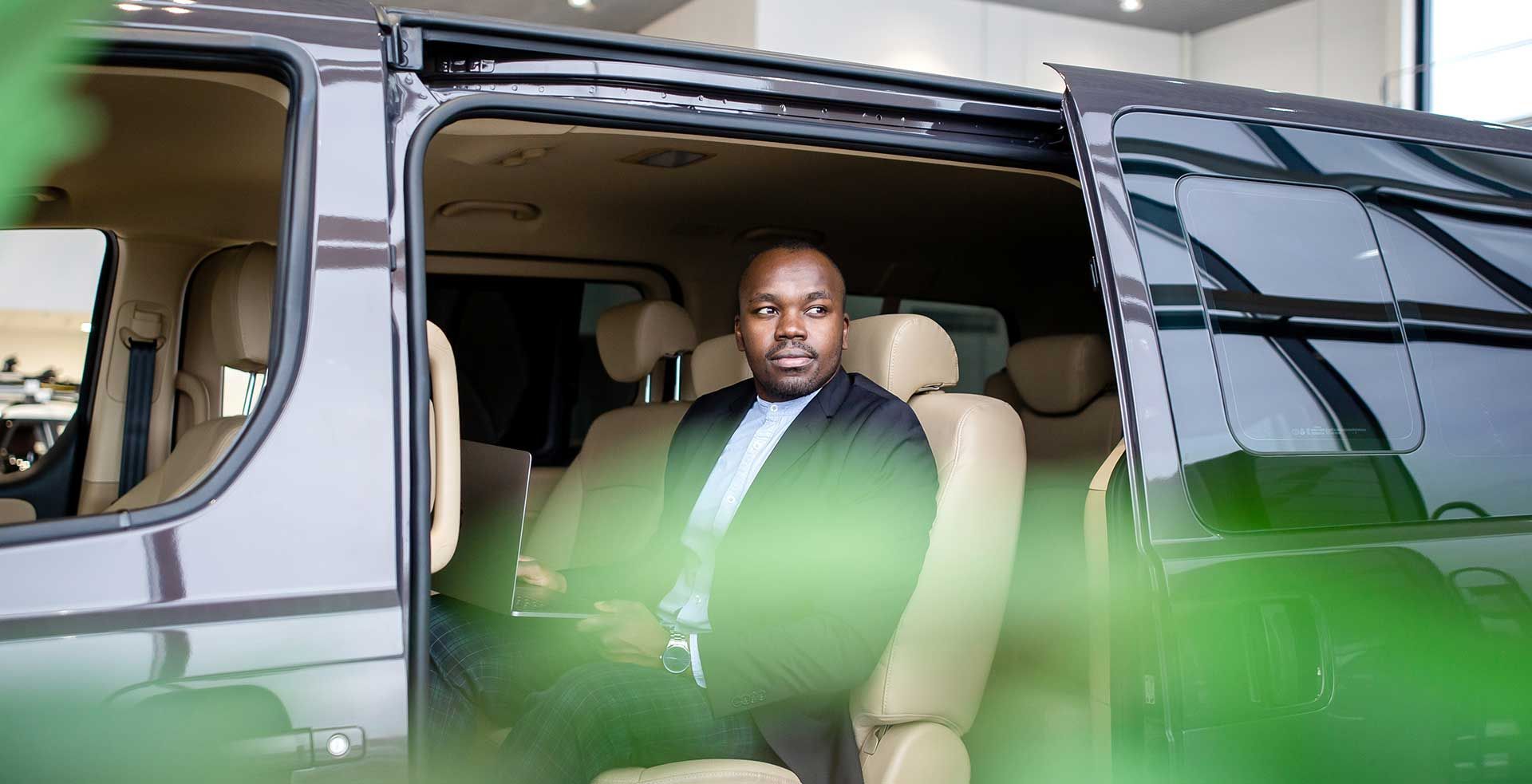 A man is taking a selfie in a limousine with two women.