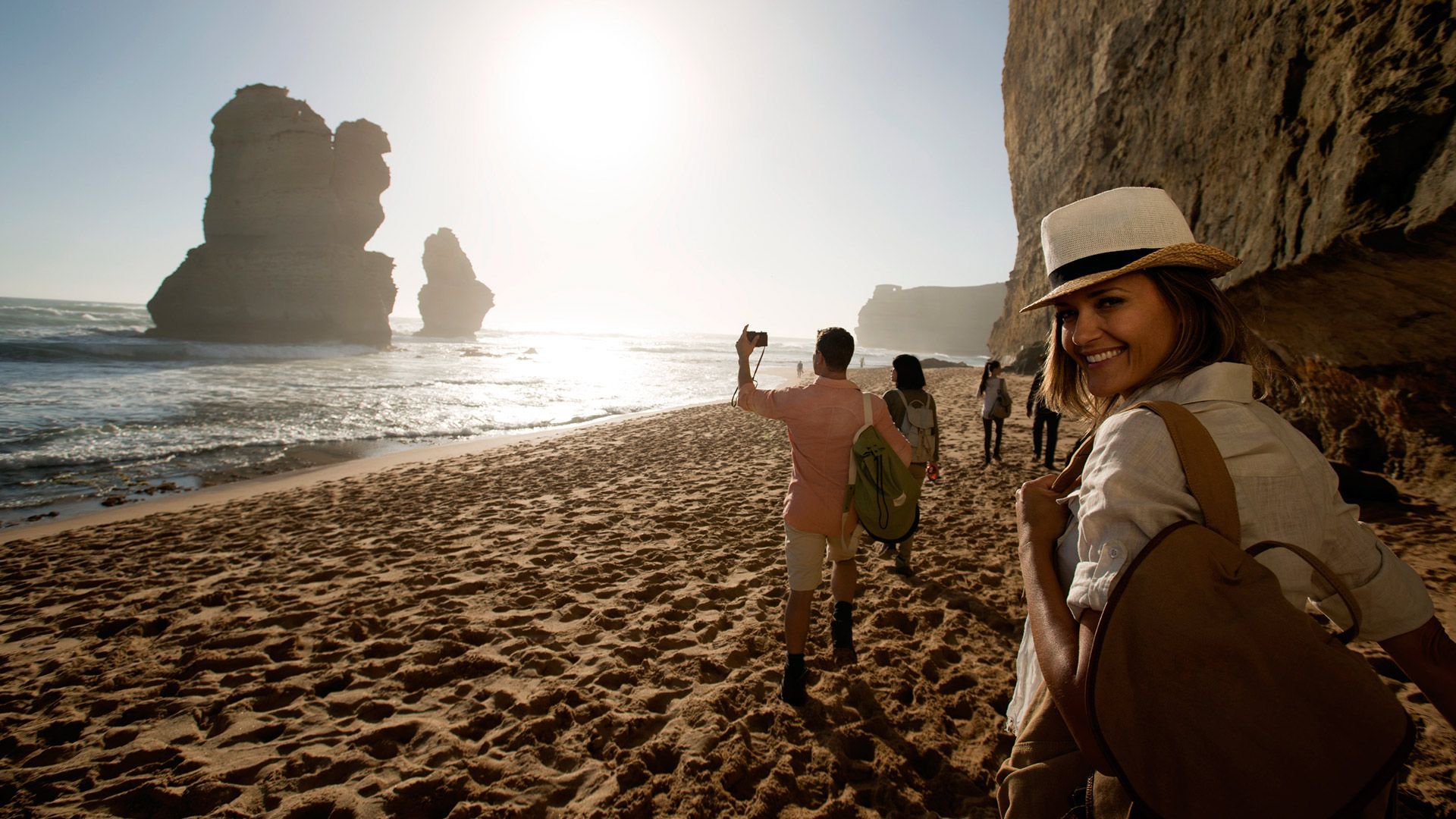 A group of people are walking along a sandy beach.