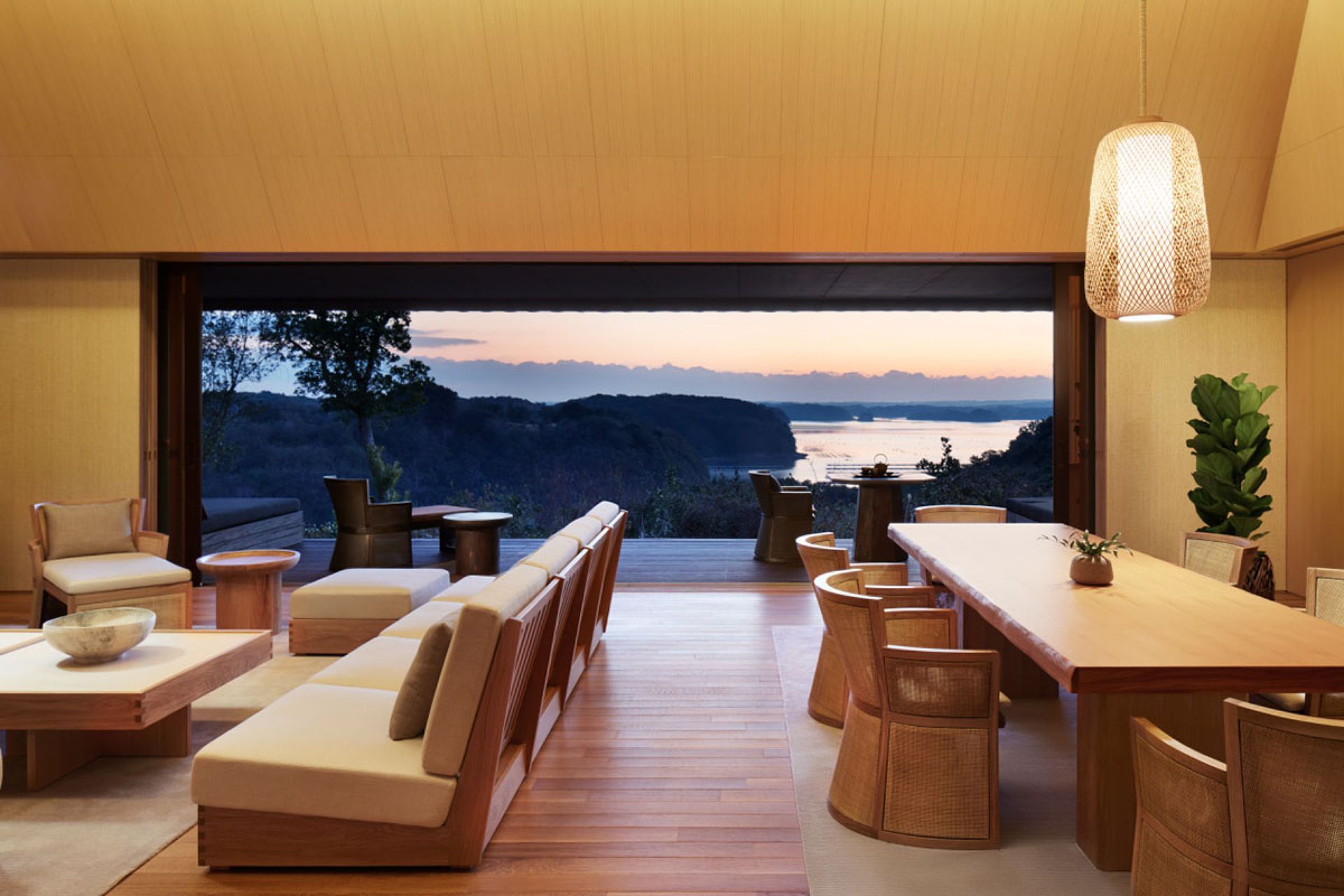 A living room with a table and chairs and a view of the ocean