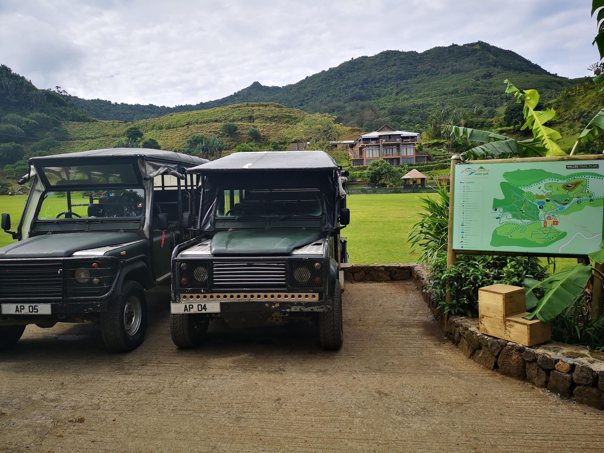 Two jeep 's are parked next to each other in a parking lot La Vanille Nature Park