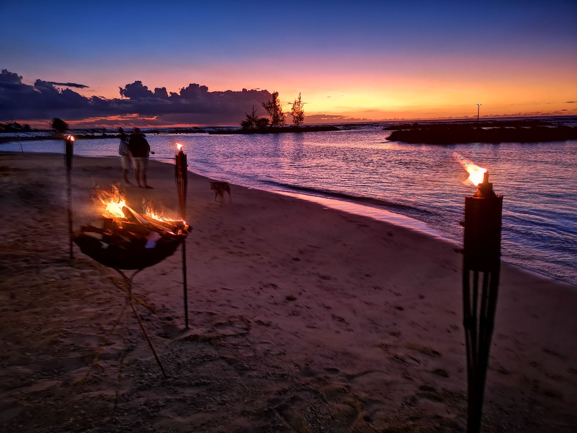 A fire pit is lit up on the beach at sunset in the North of Mauritius