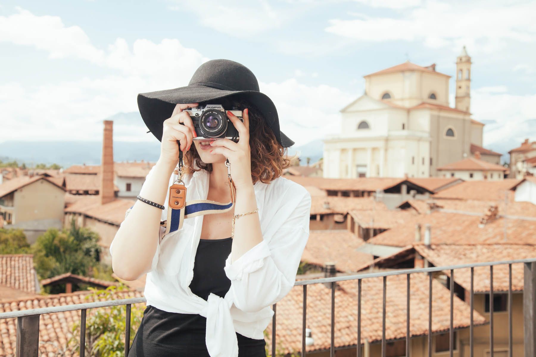 A woman is taking a picture of a city with a camera.