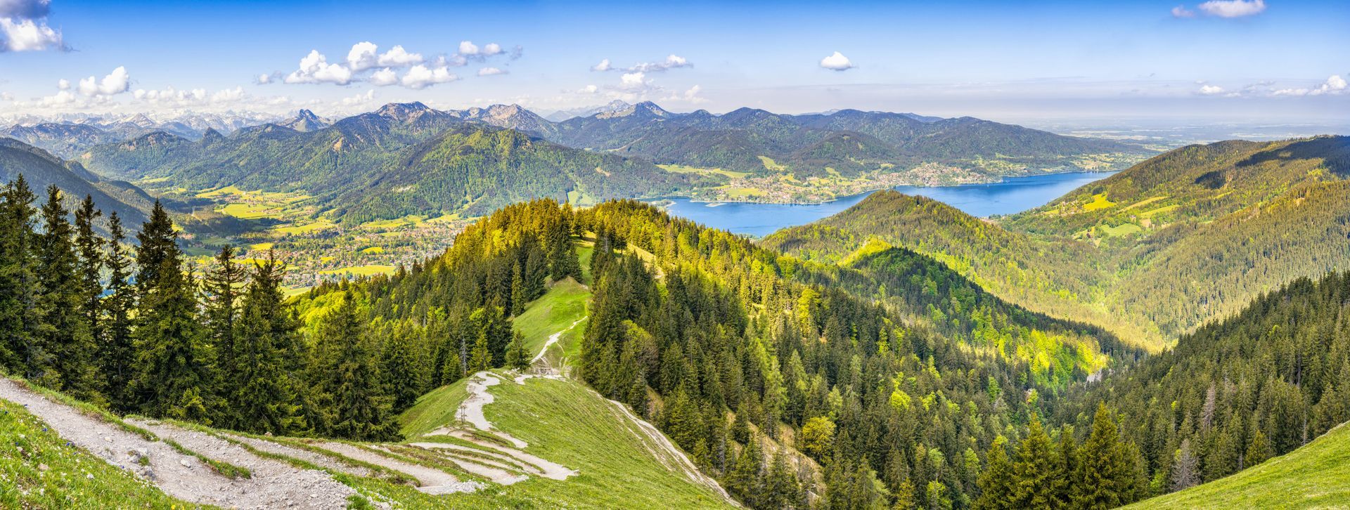 A panoramic view of a mountain valley with a lake in the background.
