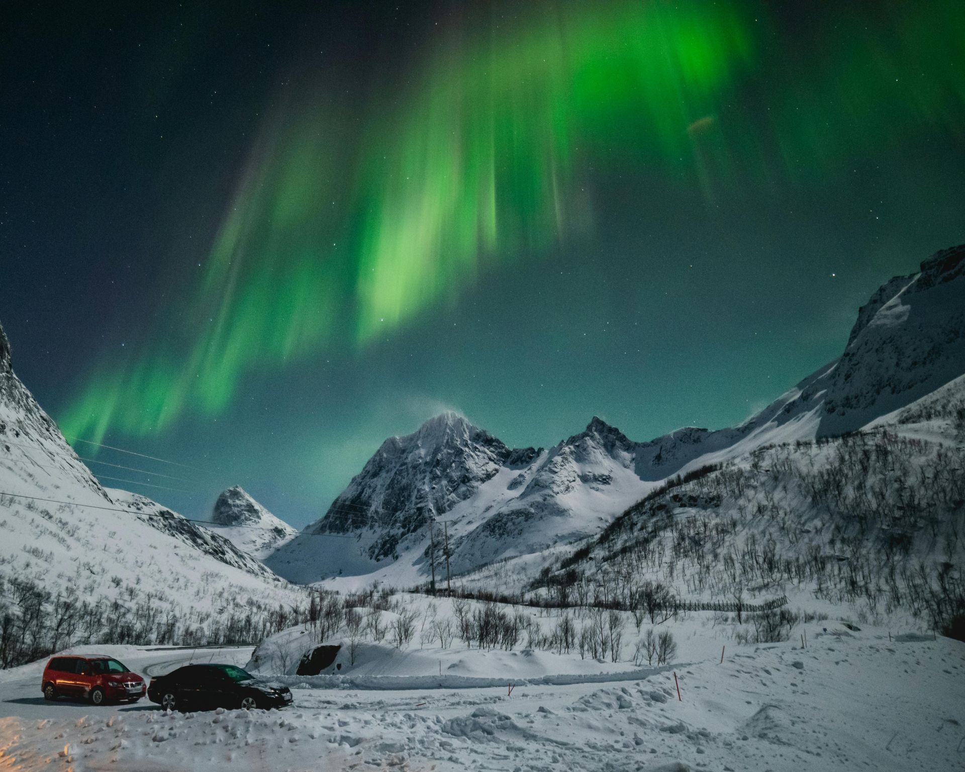 The aurora borealis is shining over a snowy mountain range Yukon