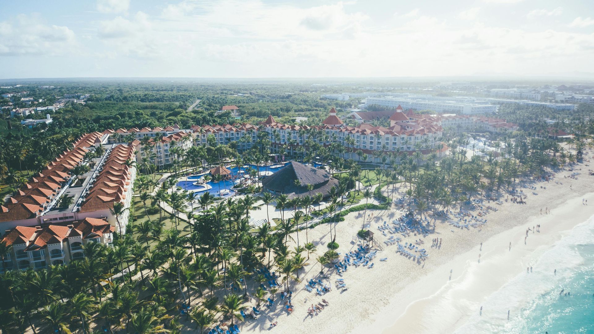 An aerial view of a beach resort surrounded by palm trees in Punta Cana