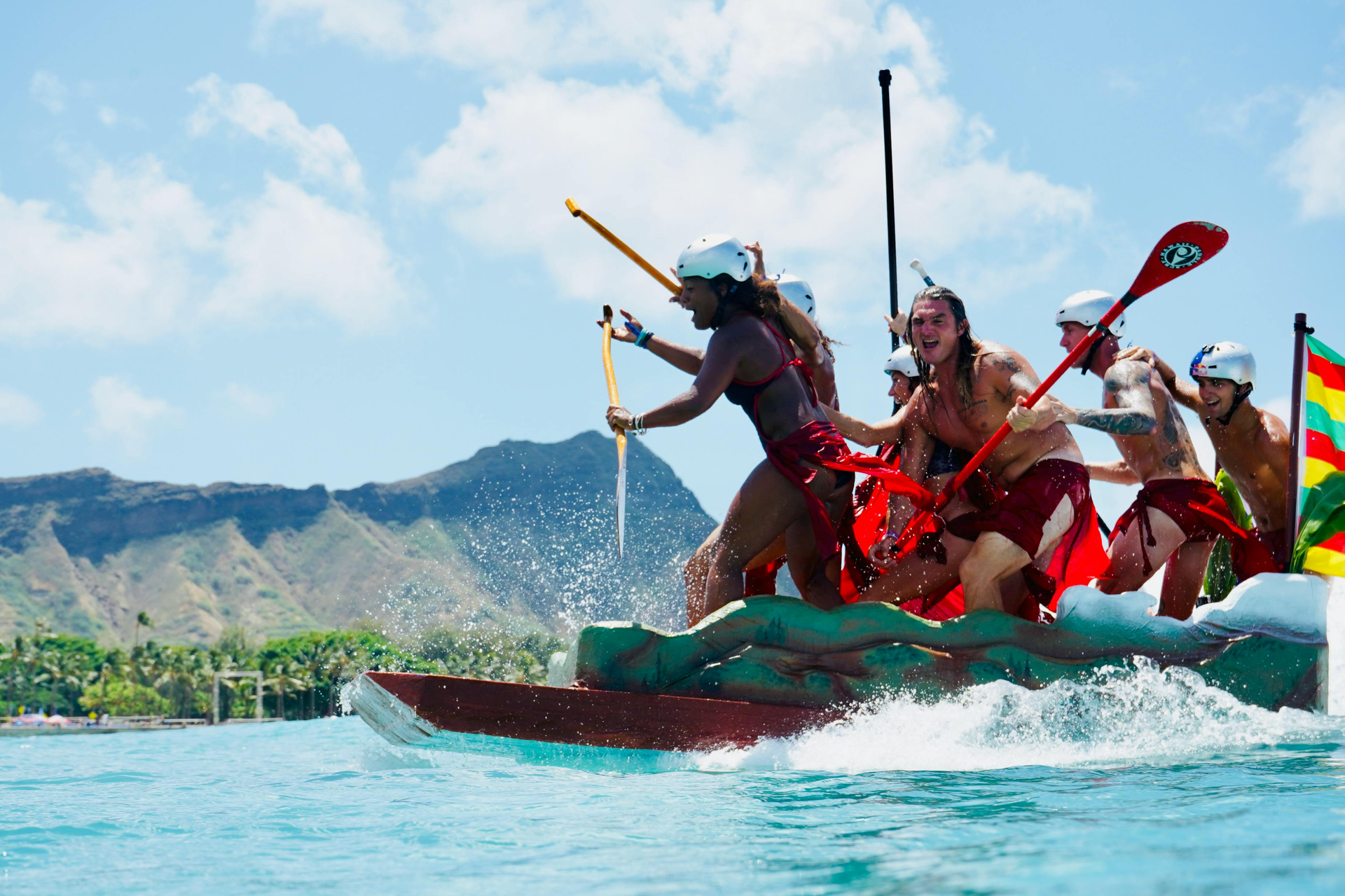 A group of people are rowing a boat in the South Pacific Ocean.