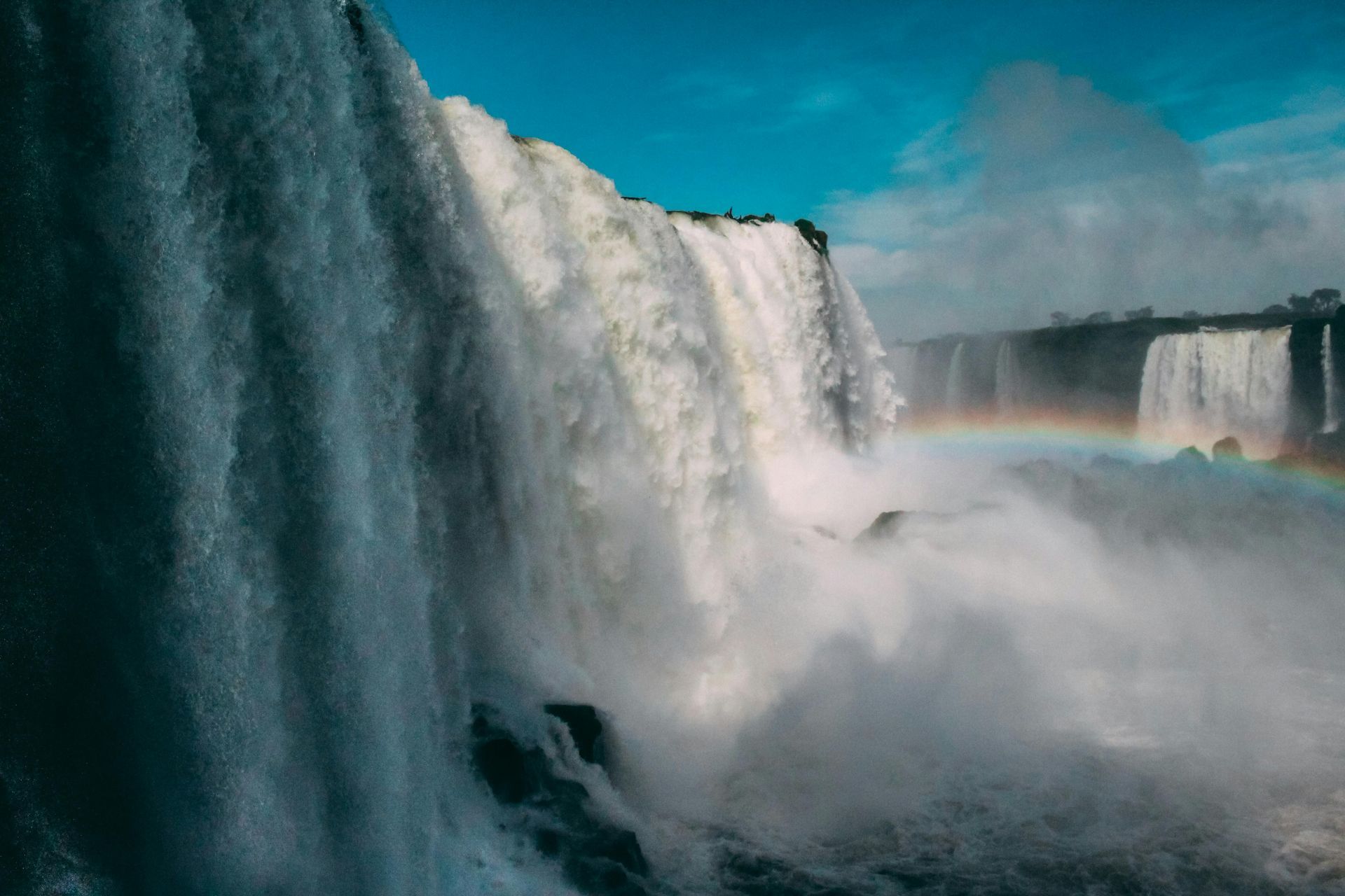 Iguazu Falls with a rainbow in the background.