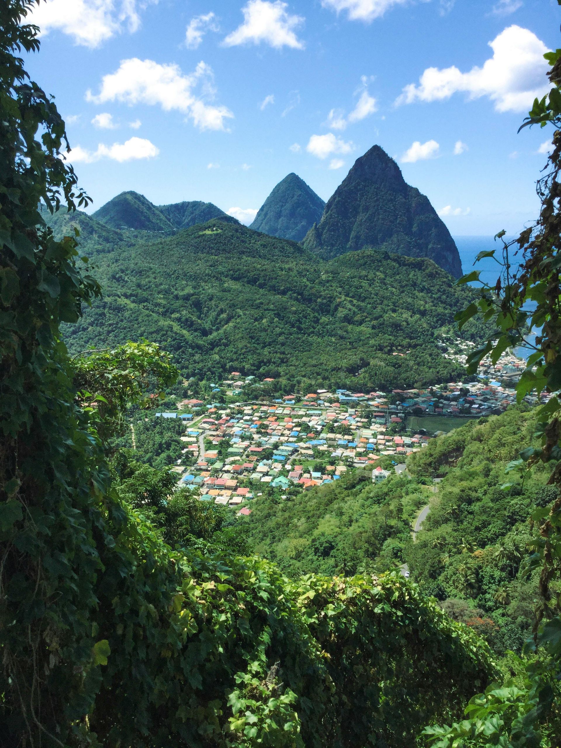 A view of a city surrounded by mountains and trees in St Lucia.