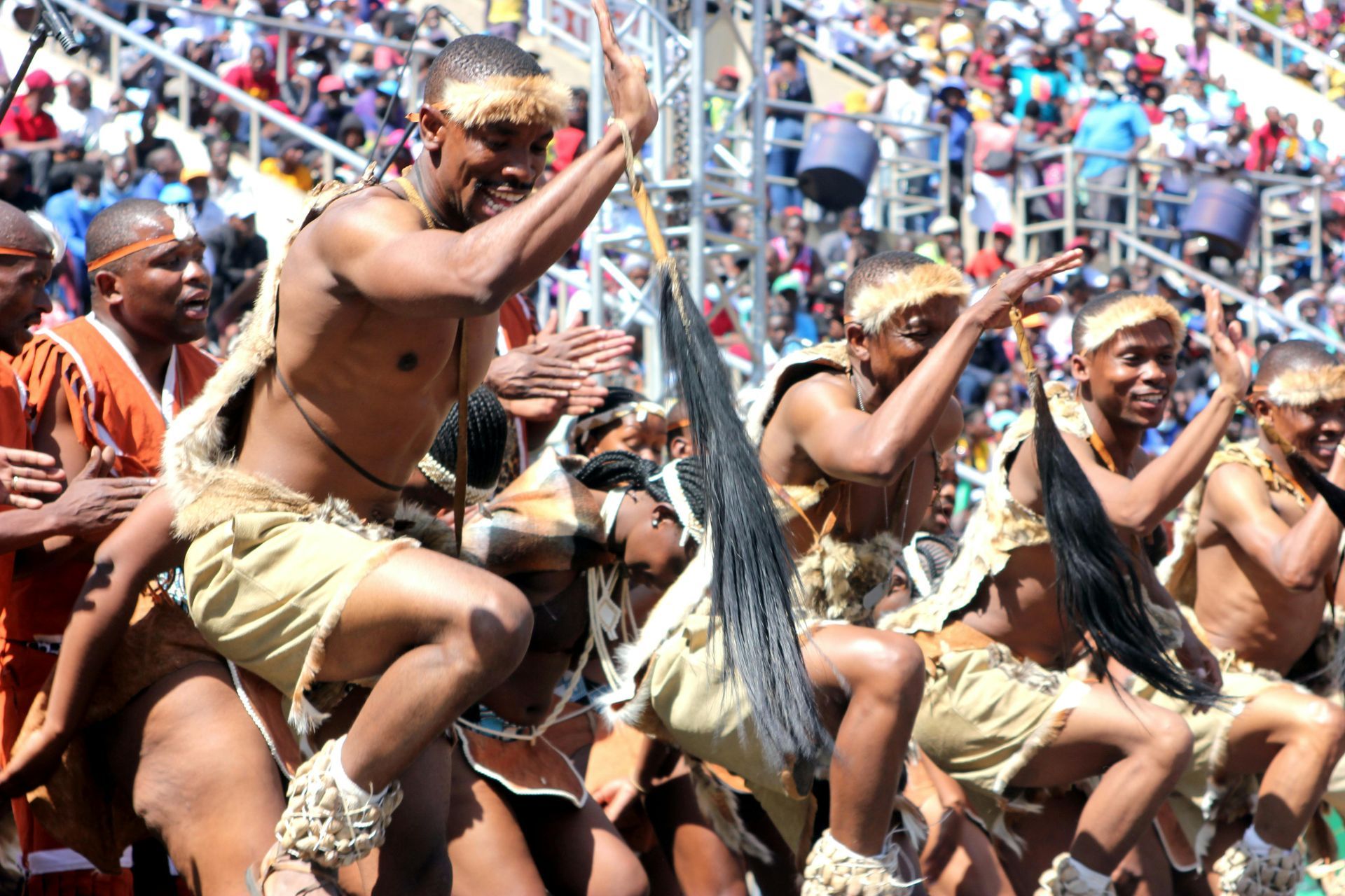 A group of men are dancing in front of a crowd known as the Shona people