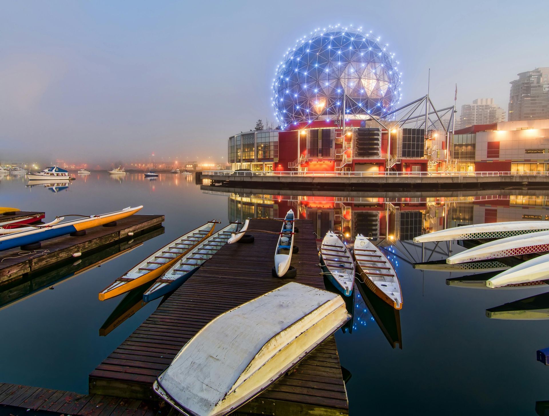 A group of boats are docked on a dock in a harbour in Vancouver