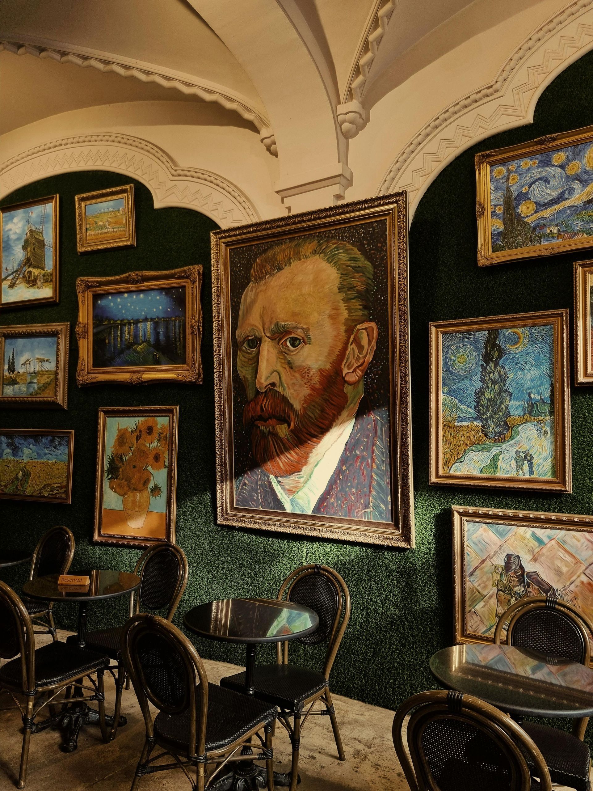 A room with a painting of Vincent Van Gogh on the wall