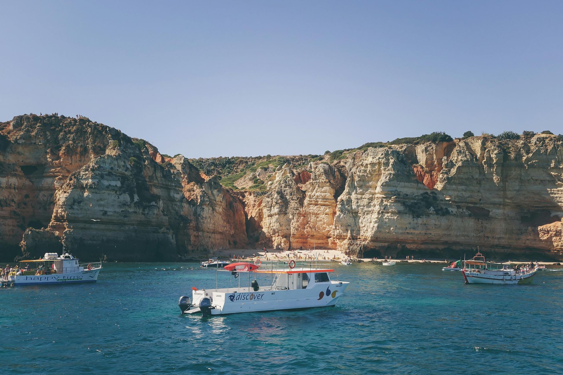 A group of boats are sailing on the Algarve Coast