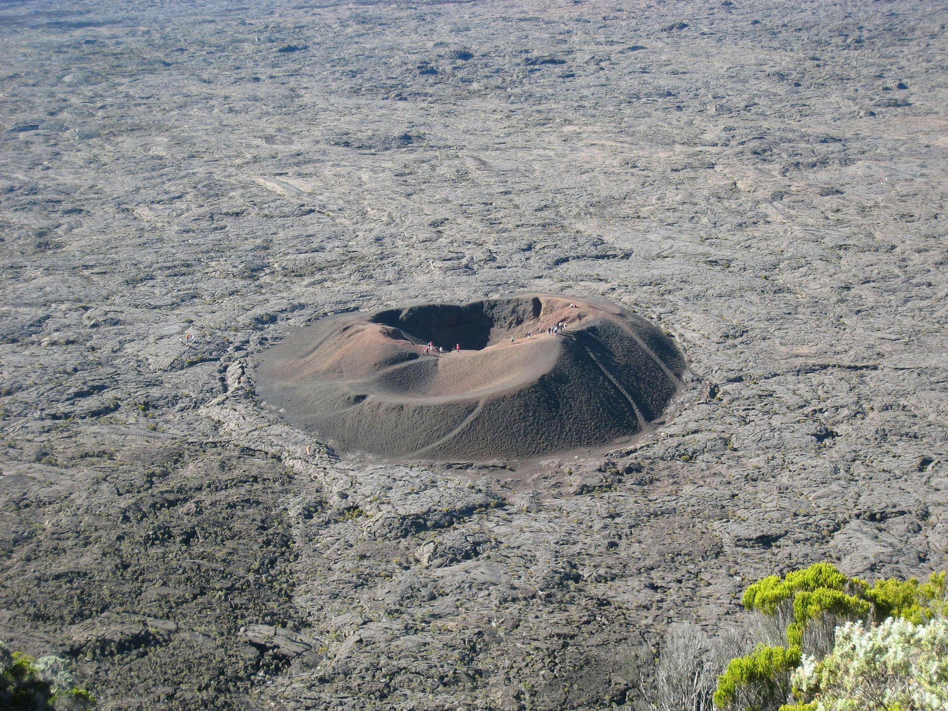 An aerial view of a large crater in the middle of a desert
