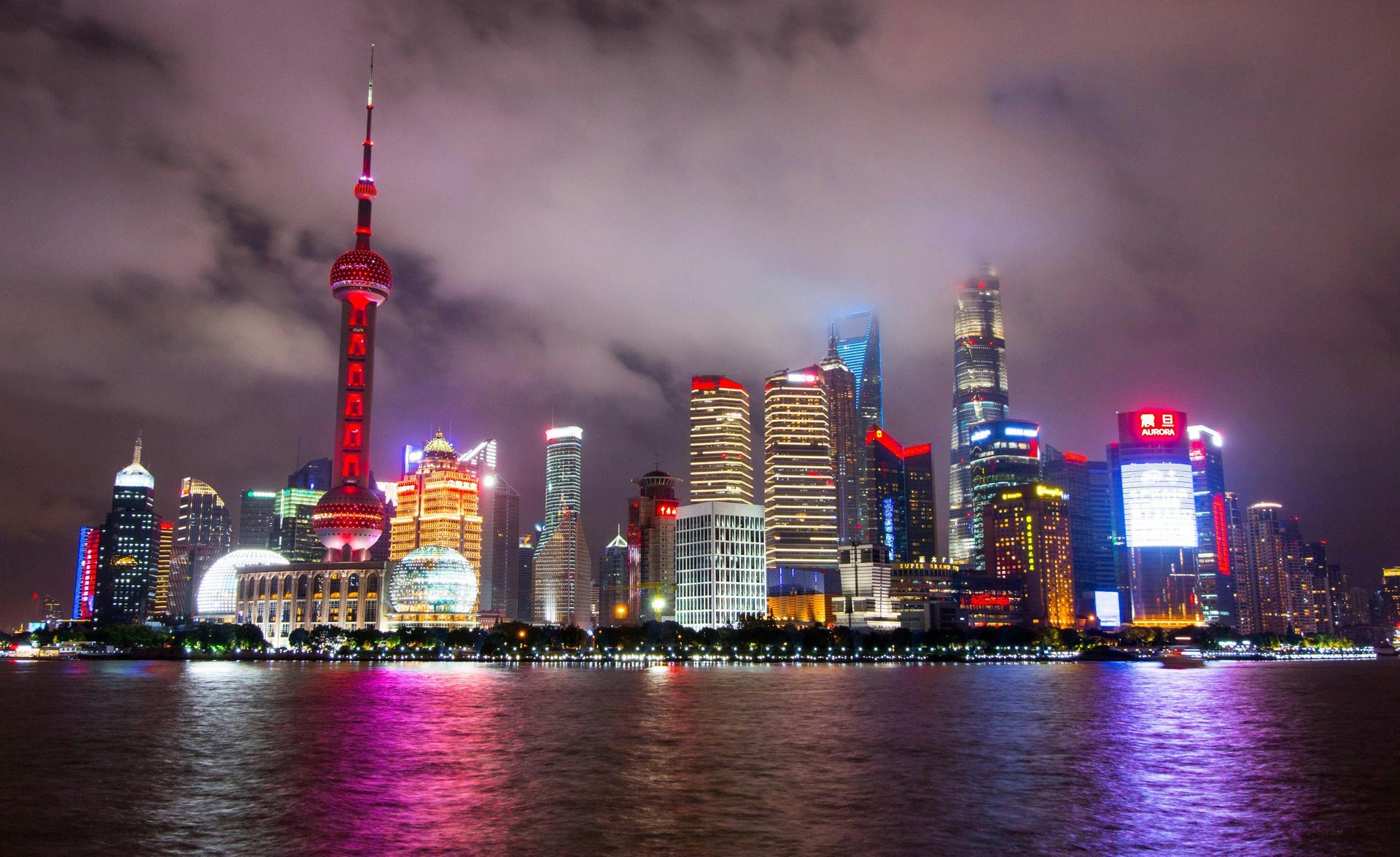 A city skyline at night with a red tower in the middle in Shanghai