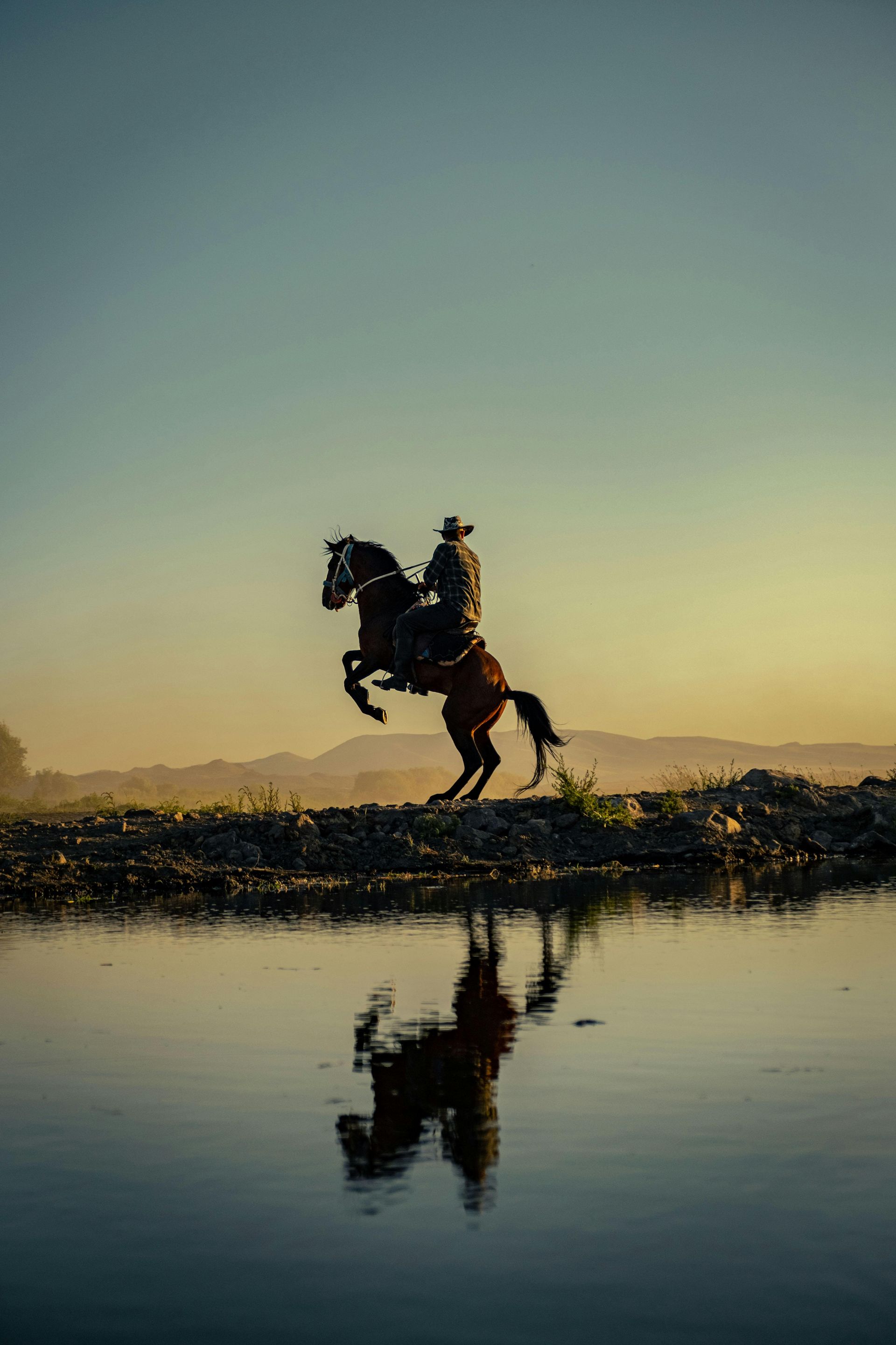 A man is riding a horse over a body of water in Texas