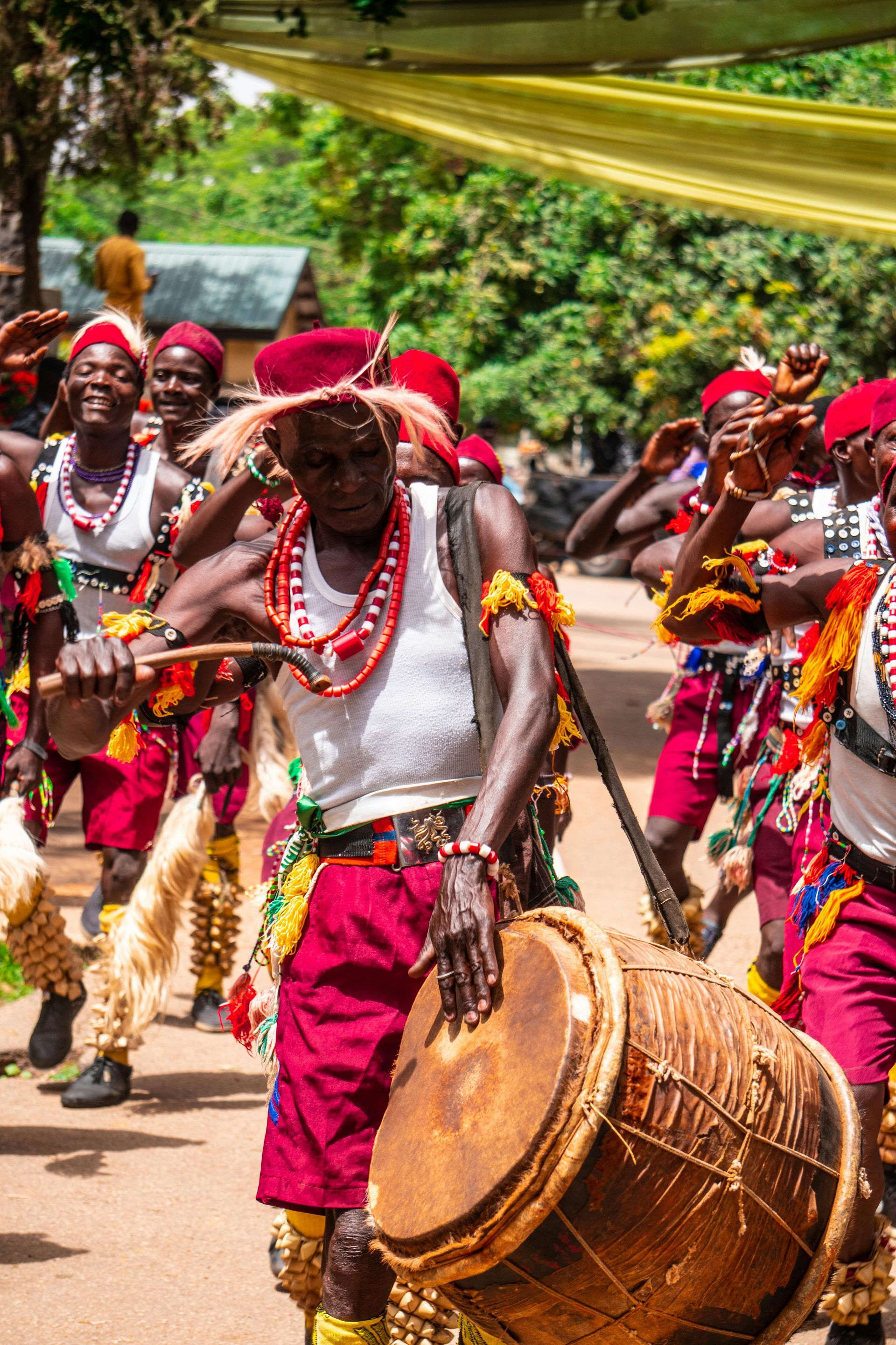 A man is playing a drum in front of a group of people.
