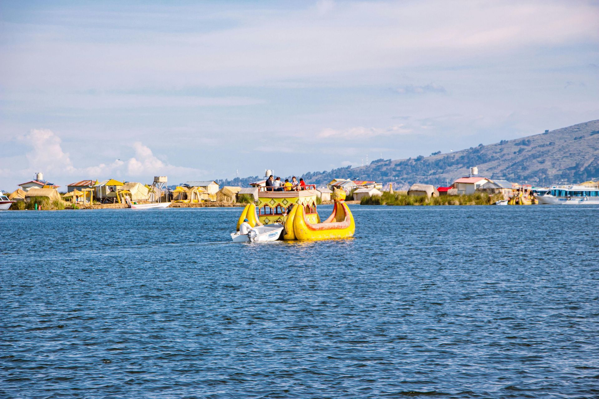 A couple of boats are floating on top of a large body of water in Lake Titicaca