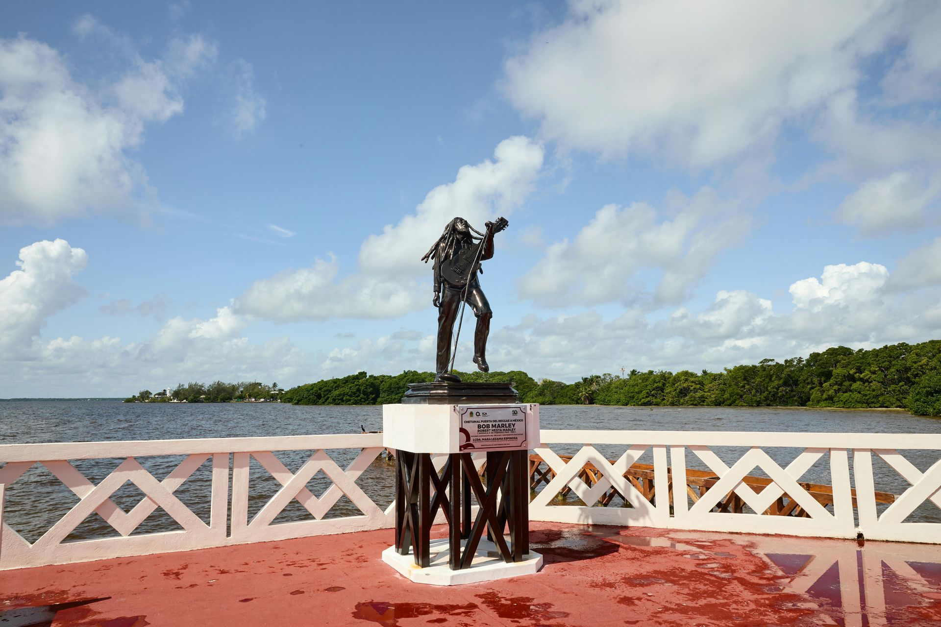 A statue of Bob Marley at his birthplace and mausoleum in front of a body of water