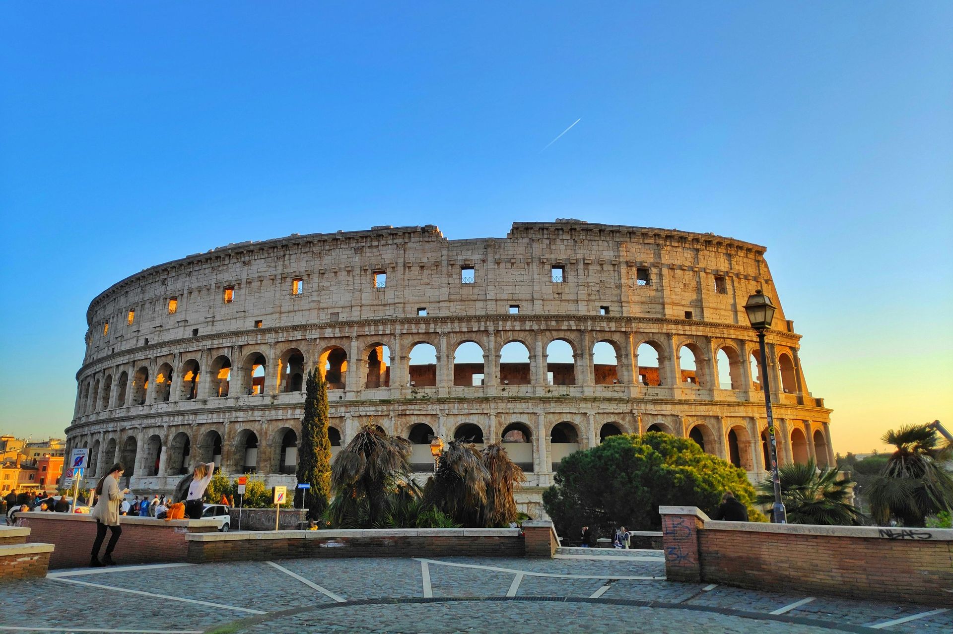 A group of people standing in front of the Colosseum in Rome