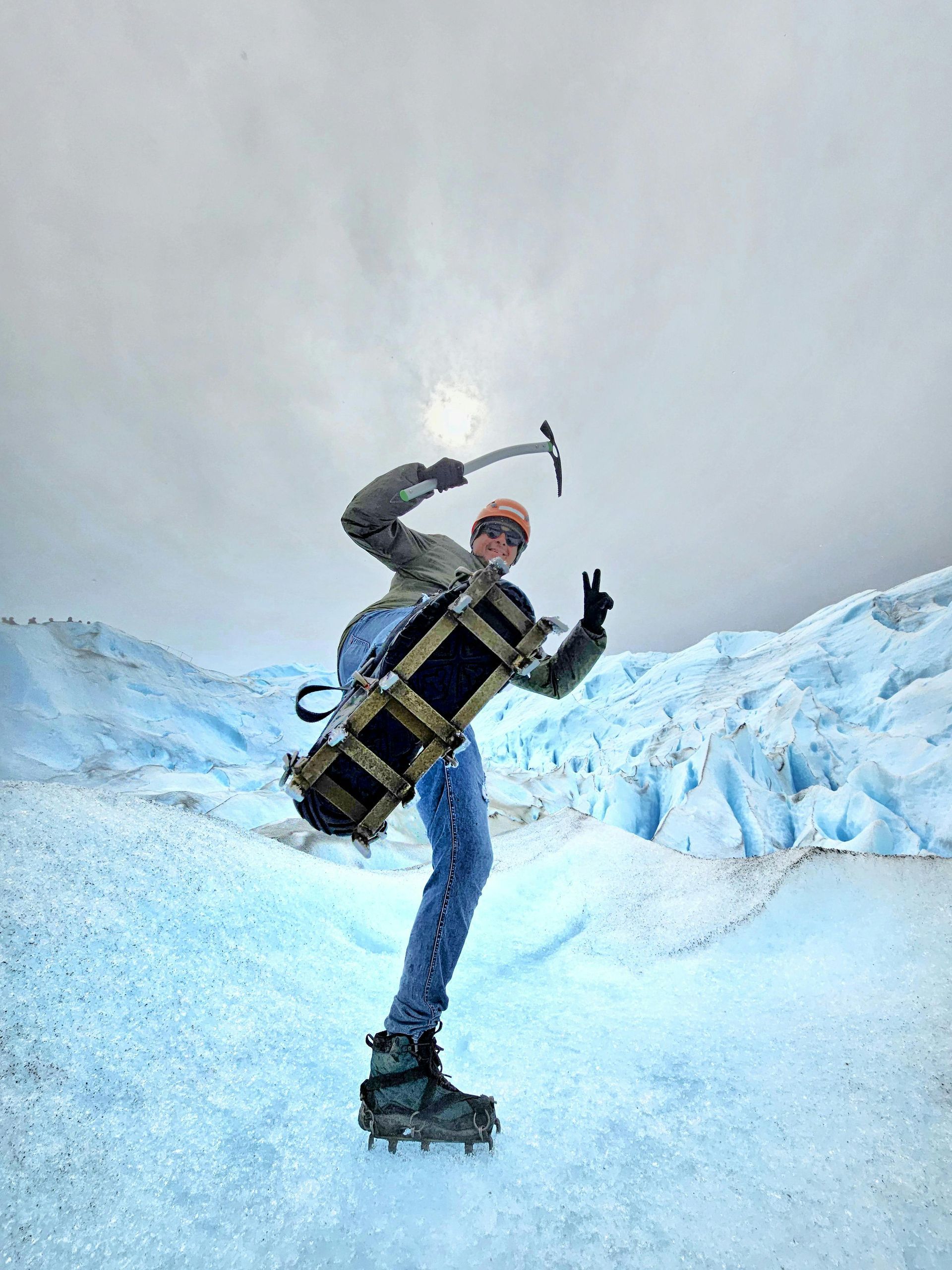 A man is standing on Glacier with crampons and a ice pick in Patagonia