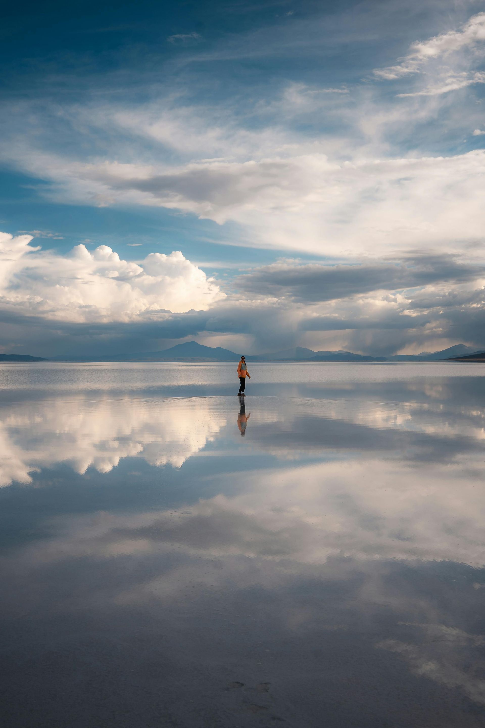 A person is standing in the middle of a large body of water.