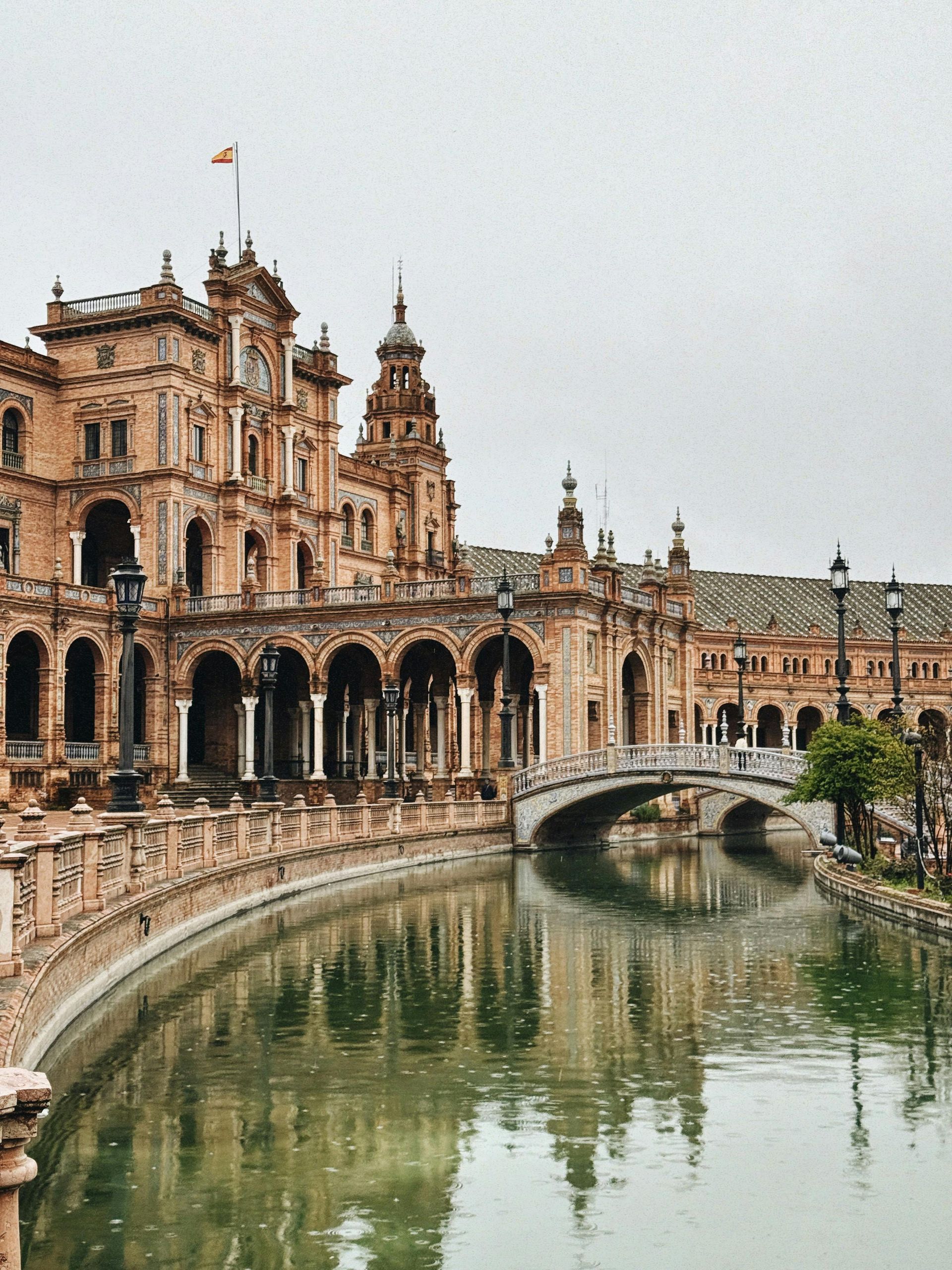 A bridge over a river with a large building in the background