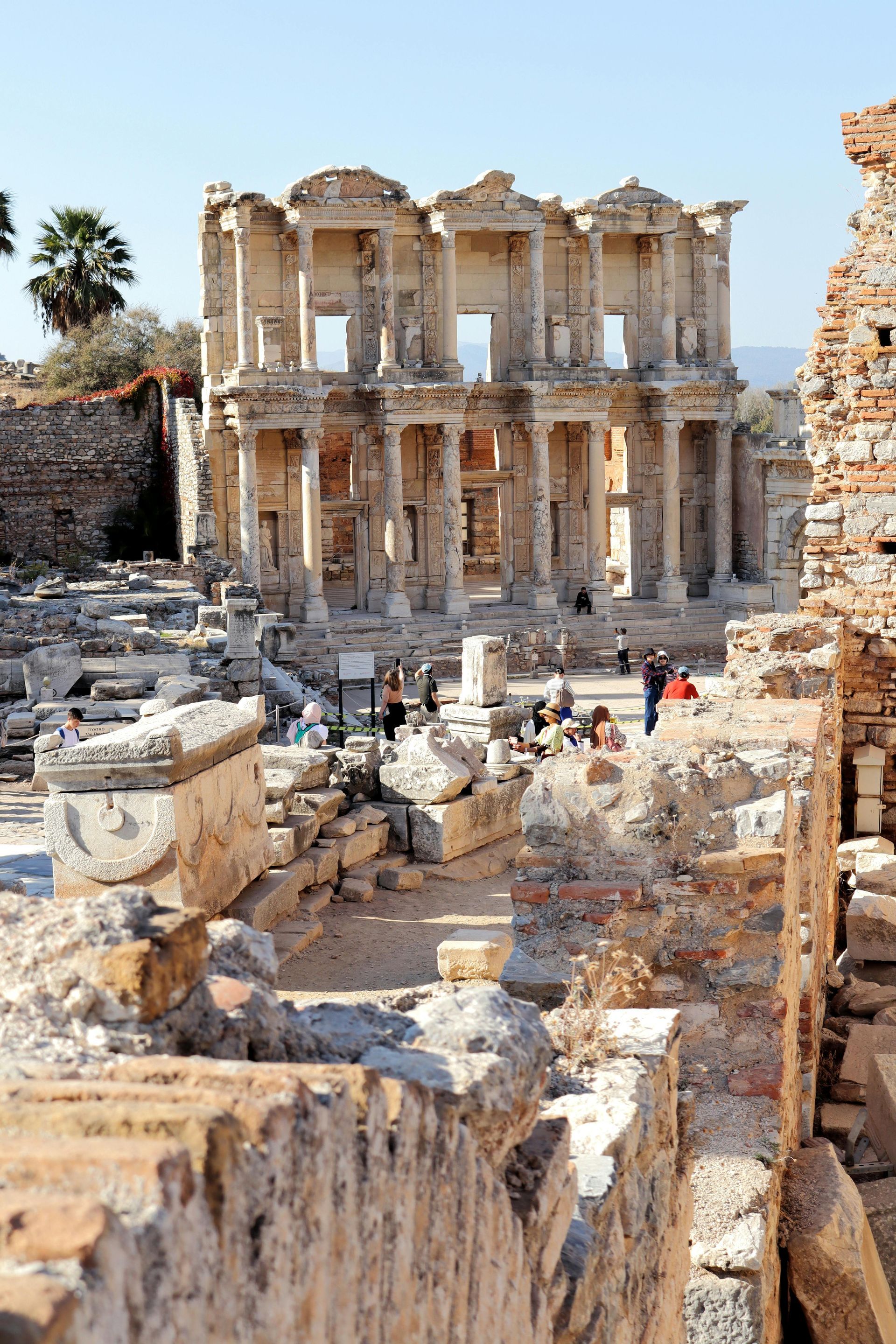A group of people are standing in front of a ruined building.